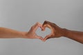 Woman and African American man making heart with hands on light grey background, closeup Royalty Free Stock Photo