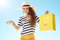 Woman against blue sky with yellow shopping bag with bikini Royalty Free Stock Photo