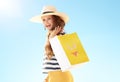 Woman against blue sky with yellow shopping bag with bikini Royalty Free Stock Photo