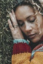 Woman against a green tree trunk covered with musk and closed eyes. Daydreaming and love nature. People female in outdoor leisure