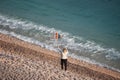 Woman age emancipation concept of old female with flying colorful kite on sunset beautiful sea beach with waves of water Royalty Free Stock Photo