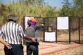 Woman aiming pistol in shooting range for competition