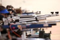 Woman aiming a pneumatic air rifle on sports competition