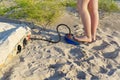 A woman with air foot pump pumps an inflatable mattress or air bed at sandy beach. Foot inflates air mattress with foot Royalty Free Stock Photo