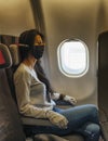 Woman in a airplane with face mask protection, coronavirus COVID19 virus Royalty Free Stock Photo