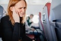 a woman on an airplane has a headache and an earache while flying on an airplane