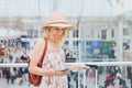 Woman in airport checking mobile phone, traveler smartphone app