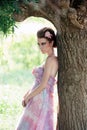 Woman in airy pink dress near the tree