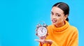 Woman, alarm clock and annoyed in studio portrait with mockup space by blue background. Gen z girl, student and model