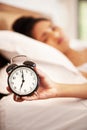 Woman, alarm and hand in bedroom, clock and tired or lazy in morning with noise alert in home. Hotel, ring and wake up Royalty Free Stock Photo