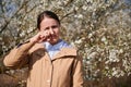 Woman allergic suffering from seasonal allergy at spring.