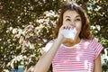 Woman with with allergy symptom blowing nose in the park Royalty Free Stock Photo