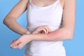 Woman with allergy symptoms scratching forearm on color background Royalty Free Stock Photo