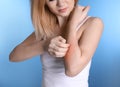 Woman with allergy symptoms scratching forearm on color background Royalty Free Stock Photo