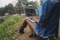 Woman alone in nature using a laptop on a camp site getaway from work or internet addiction concept Royalty Free Stock Photo