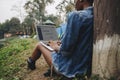 Woman alone in nature using a laptop on a camp site getaway from work or internet addiction concept Royalty Free Stock Photo