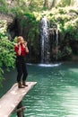Woman alone sitting, motorcyclists travelers. travel nature Forests, mountains, beautiful waterfall on background. summer day.