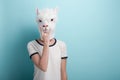 Woman in alpaca mask with hand in rock sign