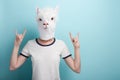 Woman in alpaca mask with hands in rock sign gesture