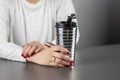 Woman with an aluminum thermos in her hands, while resting at a table