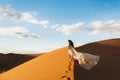 Woman in silk wedding dress with fantastic view of Sahara desert sand dunes Royalty Free Stock Photo