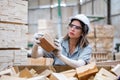 woman American African wearing safety uniform and hard hat working quality inspection of wooden products at workshop manufacturing