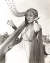 Woman in ancient Greek costume playing harp