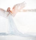 Woman angel with wings in the winter. Snow angel standing in the snow, the Keeper of winter, a fabulous image.