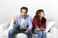 Woman angry and upset while husband or boyfriend plays videogames ignoring her