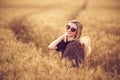 woman in animal print dress, straw hat in front of Sun in middle