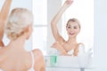 Woman with antiperspirant deodorant at bathroom