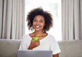Woman, apple and laptop on sofa for snack, wellness or diet for break, vitality or eat for health at home. Freelancer Royalty Free Stock Photo