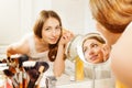 Woman applies eyebrow shadows with brush in bath Royalty Free Stock Photo