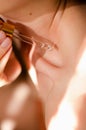 A woman applies oil to body. A drop of essential oil drips from a pipette onto a woman`s collarbone. Serum for the body