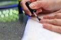 A woman applies a primer to her nails before applying varnish. Close-up of a hand.