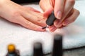 A woman applies a primer to her nails before applying varnish. Close-up of a hand.