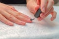 A woman applies a primer to her nails before applying varnish. Close-up of a hand.