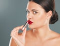 Woman apply lipstick, red on lips and face in portrait with makeup and beauty isolated on studio background. Cosmetic Royalty Free Stock Photo