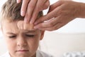 Woman applying adhesive bandage on boy`s forehead indoors Royalty Free Stock Photo