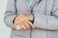 Woman applying alcohol spray against coronavirus. Closeup of female hand disinfecting hands with antiseptic spray, outdoors