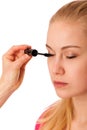 Woman applying black mascara on eyelashes, doing makeup. Royalty Free Stock Photo