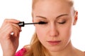 Woman applying black mascara on eyelashes, doing makeup. Royalty Free Stock Photo