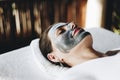 Woman applying charcoal face pack