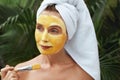 Woman Applying Clay Mask With Brush. Model In Bath Towel Using Skin Care Product For Oil Derma.