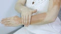 Woman applying clay mask on her arm