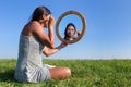 Woman applying cosmetics mascara makeup in mirror outside