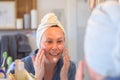 Woman applying cram on her face after shower Royalty Free Stock Photo