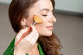 Woman applying dry cosmetic tonal foundation