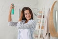 Woman applying dry shampoo onto her hair in bathroom Royalty Free Stock Photo