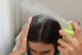 Woman applying dry shampoo onto her hair, closeup Royalty Free Stock Photo